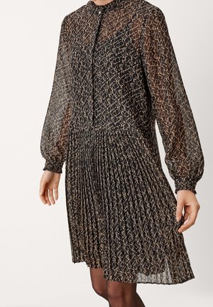 Robe noire semi-transparente à manches longues avec imprimé abstrait beige, jupe plissée et col haut avec fermeture par bouton à la gorge.