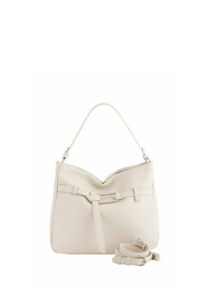 Cremefarbene Handtasche aus strukturiertem Leder mit einem oberen Griff, dekorativem Riemendetail und einem abnehmbaren, passenden Schulterriemen, der daneben aufgewickelt liegt.