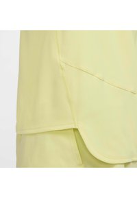 Helles gelbes Sportshirt aus strukturiertem Stoff. Mit abgerundetem Saum und flachen Nähten für eine glatte Silhouette und bequemen Sitz.