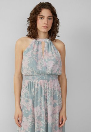 Vloeiende jurk van lichtblauwe stof met roze bloemenpatronen. Heeft een halternek, een sleutelgatdetail en een gatherde, textuurmatige taille.