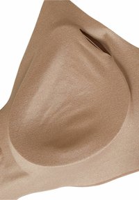 Beige sömlös bh med formgjutna kupor. Slät tygtextur, lätt lyster och detalj med öppning. Ergonomisk form designad för komfort.