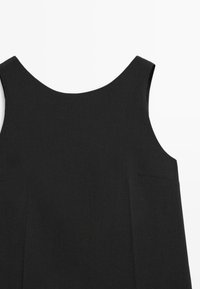  Czarna sukienka bez rękawów z zaokrąglonym dekoltem, gładką teksturą i minimalistycznymi przeszyciami. Z boku znajduje się dyskretna kieszeń.