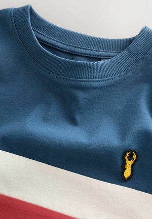 Cotton crewneck sweatshirt in blue with horizontal red, white, and navy stripes. Features a yellow embroidered deer logo on the chest.