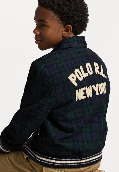 Casaco de corduroy xadrez em verde escuro e azul-marinho, com "POLO R.L. NEW YORK" bordado em creme nas costas. Punhos listados em canelado.