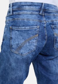 Blauwe denim jeans met een vervaagde wassing, dubbele stiksels op de zakken en een klassiek vijf-pocket ontwerp met een kenmerkende vorm van de achterzakken.