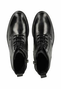 Stivaletti in pelle nera alla caviglia con design a stringhe e zip laterali, caratterizzati da una superficie liscia e punta rotonda. Estetica minimalista, senza fantasie.