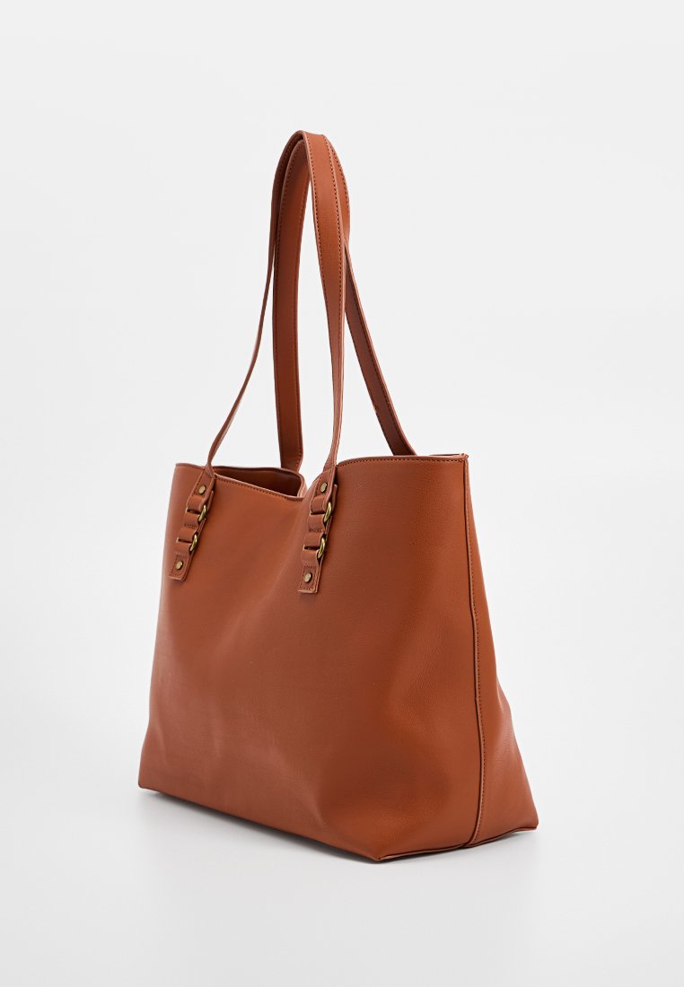 Bolso tote de cuero marrón con dos correas largas, textura suave, tres acentos de metal dorado en la parte frontal, forma rectangular, diseño sin embellishments.