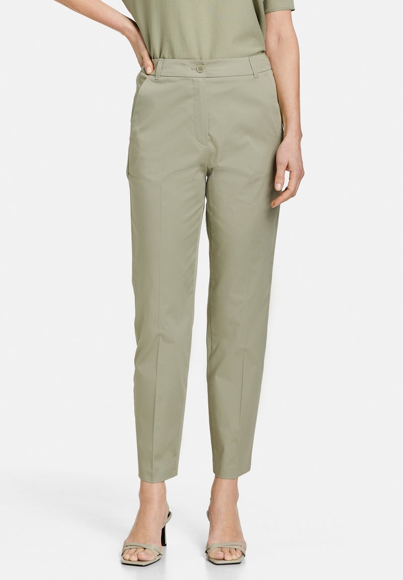 Light khaki pants with a tailored fit, smooth texture, front pockets, and a single button closure at the waist. Cropped length.