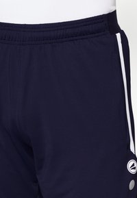 Pantaloni sportivi da uomo in navy con elastico in vita, caratterizzati da strisce bianche laterali e un piccolo logo sull'orlo inferiore. Realizzati in materiale leggero.