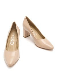 Beżowe lakierowane szpilki z kwadratowym słupkiem, spiczastym noskiem oraz wyściełanym wnętrzem, na którym widnieje nazwa marki „RYŁKO.”