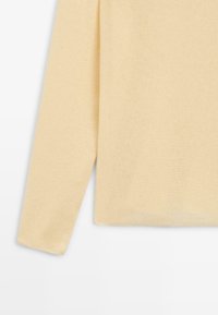 Beiger langärmeliger Strickpullover, Ärmel und Saum vor einem weißen Hintergrund, zeigt einen weich strukturierten Stoff.