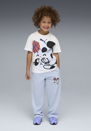 White cotton t-shirt with black cat graphic and basketball design, paired with light blue sweatpants featuring a matching graphic. Blue sneakers.