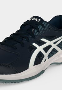 Σκούρο μπλε αθλητικό παπούτσι Asics με λευκό ριγέ λογότυπο, μαύρα κορδόνια και λευκή σόλα με ορατό γκρι πέλμα σε απλό φόντο.