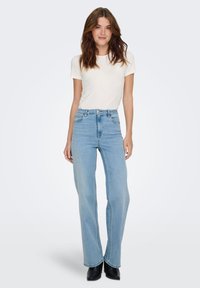 High-waisted light blue jeans with a straight leg design, subtle faded effect, and front pockets, paired with a fitted white t-shirt.