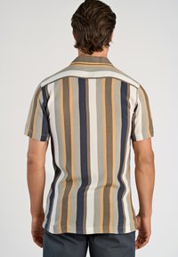 Kortermet skjorte med vertikale striper i beige, brunt, marineblått og krem; glatt stoff med klassisk krage og bakstykke detalj.