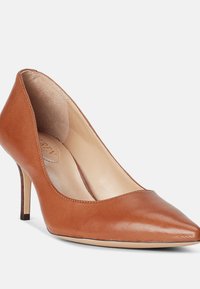 Korkean kantapään tan-värinen nahkakenkä, jossa on teräväkärkinen muotoilu, pitkänomainen siluetti ja hoikka stiletto-kanta. Sisäpuolella on sileä vuori.