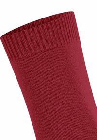 Tessuto a maglia rossa con dettagli di polsino elasticizzato a coste su una manica di abbigliamento.