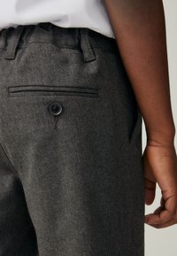 Graue Wollmischungs-Hosen mit glatter Textur, elastischem Bund und einer Gesäßtasche mit schwarzem Knopfdetail.