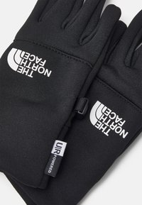 Svarte hansker laget av et glatt, elastisk materiale, med hvite logoer på baksiden og en liten etikett med teksten "UIR Powered."