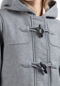 Grå uldfrakke med hætte, togglespænder og en lomme med en glat overflade. Designet er enkelt og funktionelt.