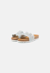 Helle blaue Wildleder-Slidesandalen mit einem strukturierten Wellenmuster, Korkfußbett und weißer Gummisohle. Offen an den Zehen und mit einer weichen, flexiblen Bauweise.
