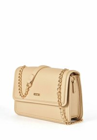 Beżowa skórzana torebka na ramię z klapą, złotym łańcuchem i minimalnymi znakami firmowymi. Gładka tekstura z detalami przeszycia.
