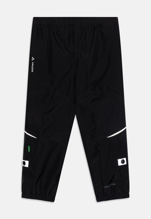 Schwarze wasserdichte Hose mit einem elastischen Bund, reflektierenden Akzenten und einer strukturierten Oberfläche. Enthält Logo und grüne Etikett-Details.
