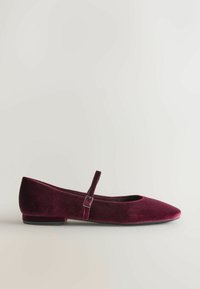 Burgundowe baletki z aksamitu z kwadratowym noskiem, delikatnym paskiem i niską, płaską podeszwą. Miękka faktura i minimalistyczny design.