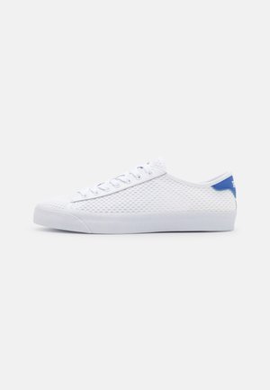 Sapatilhas brancas em rede com um design texturizado, detalhe azul no calcanhar e sola branca plana. Apresentam atacadores redondos e um estilo minimalista.
