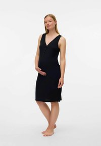 Abito premaman nero a costine con scollo a V, design senza maniche, dettagli in bottoni e lunghezza al ginocchio. Texture morbida che esalta la silhouette.