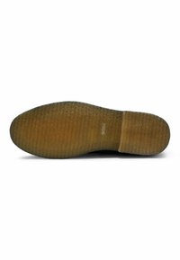 Suola della scarpa con un motivo testurizzato e ondulato. Materiale in gomma marrone con un bordo liscio. Logo impresso vicino all'area del tallone.