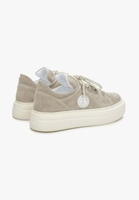 Niskie sneakersy z zamszu w jasnym beżu z okrągłymi białymi gumowymi podeszwami. Oferują tonowane sznurowadła oraz okrągły akcent logo po boku.