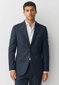 Námornícky blazer s prúžkami vyrobený z textilného materiálu, s dvoma prednými vreckami, jedným gombíkovým zapínaním a kontrastnou vreckovkou.