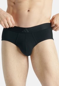 Svart bomullsboxer med en bred elastisk midjeband som har en subtil ton-i-ton-logotyp, designad för komfort med en formad framficka.