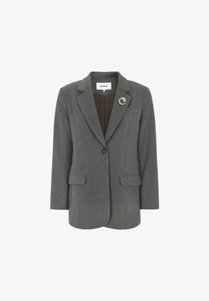 Szürke kockás blézer, amely testre szabott szabású, visszahajtott gallérral, egygombos záródással, két elülső zsebbel, és egy díszcsattal a bal oldalon.