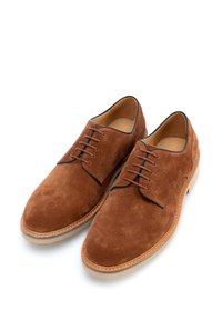 Scarpe da uomo in suede marrone con finitura liscia, punta tonda, design con lacci e bordi cuciti in contrasto. Hardware e dettagli minimalisti.