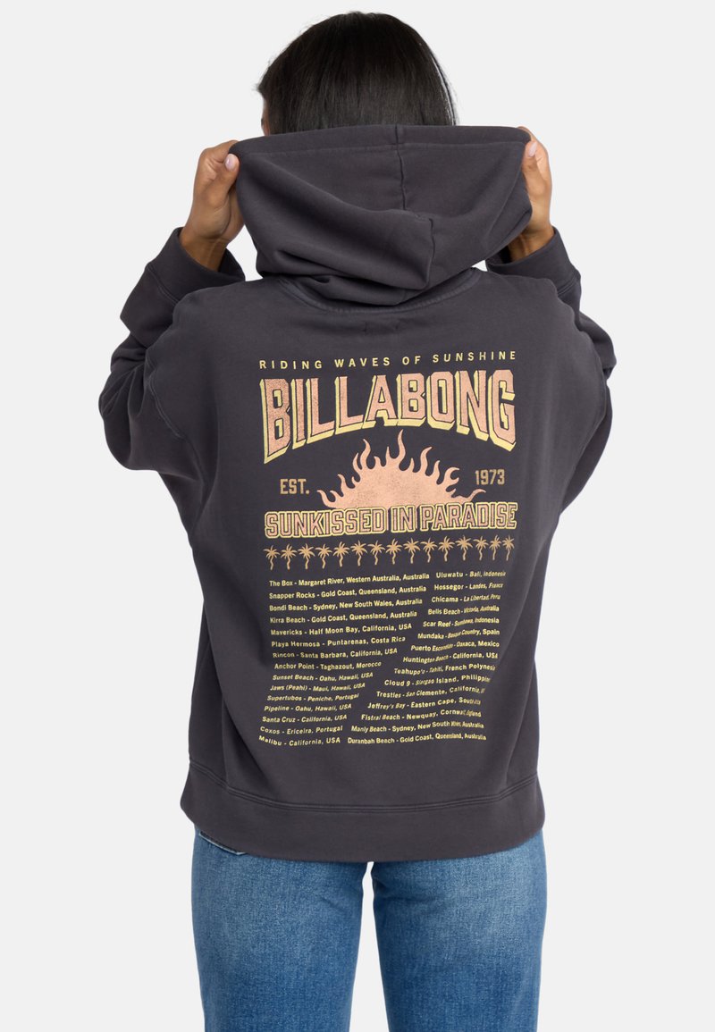 Sweatshirt capuz preto com um grande logótipo "BILLABONG" e gráfico de sol nas costas, com texto a detalhar várias localizações de surf.