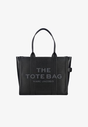Svart läder tote-väska med dubbla topphandtag, texturerad yta och tryckt text: "THE TOTE BAG MARC JACOBS" på framsidan.