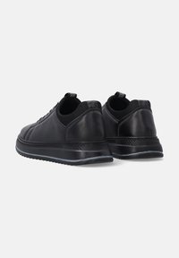 Schwarze Ledersneaker mit glatter Textur, runder Form, gepolsterter Lasche und Gummisohle, verziert mit einem dezenten silbernen Akzent entlang der Kante.