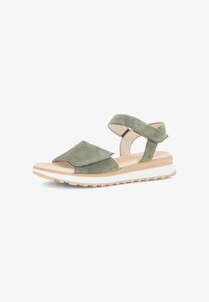 Green suede open-toe sandal with adjustable ankle and front straps, beige cushioned sole, and white treaded outsole.