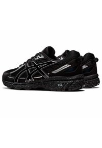Pantofi atletici negri cu un material superior texturat, accente reflectorizante și o talpă neagră cu pete. Prezintă un toc cu amortizare și un sistem de șireturi.
