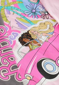 Grafisk T-shirt med tecknade karaktärer i en rosa cabriolet, omgiven av färgglada blommor och palmer. Mjuk bomullsmaterial.