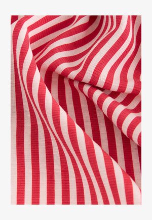 Röd- och vitrandigt tyg med vågiga linjer och en strukturerad väv, draperat i mjuka veck.