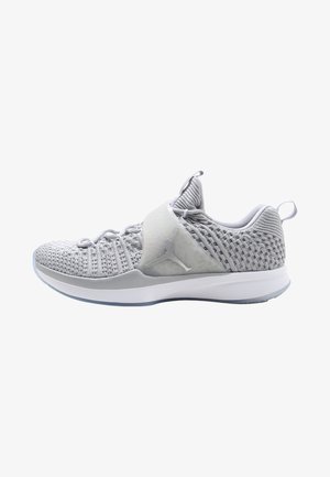 Chaussure de sport gris clair avec texture tricotée, bride réglable, languettes de traction et semelle blanche, vue de côté sur fond blanc.
