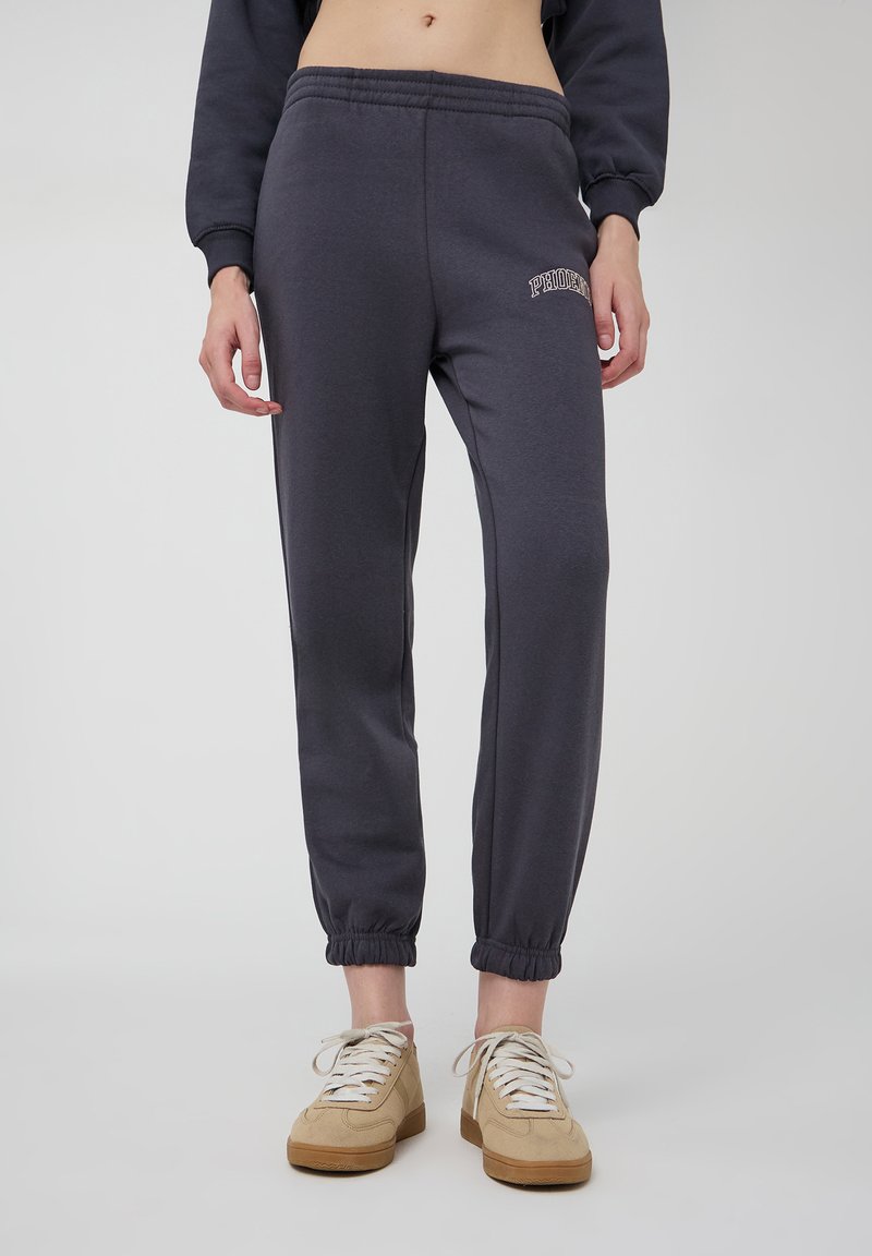 Ciemnoszare dresy z elastycznymi mankietami, z haftowanym logo "PHOENIX" na lewej udzie. Wykonane z miękkiego materiału, idealne do codziennego noszenia.