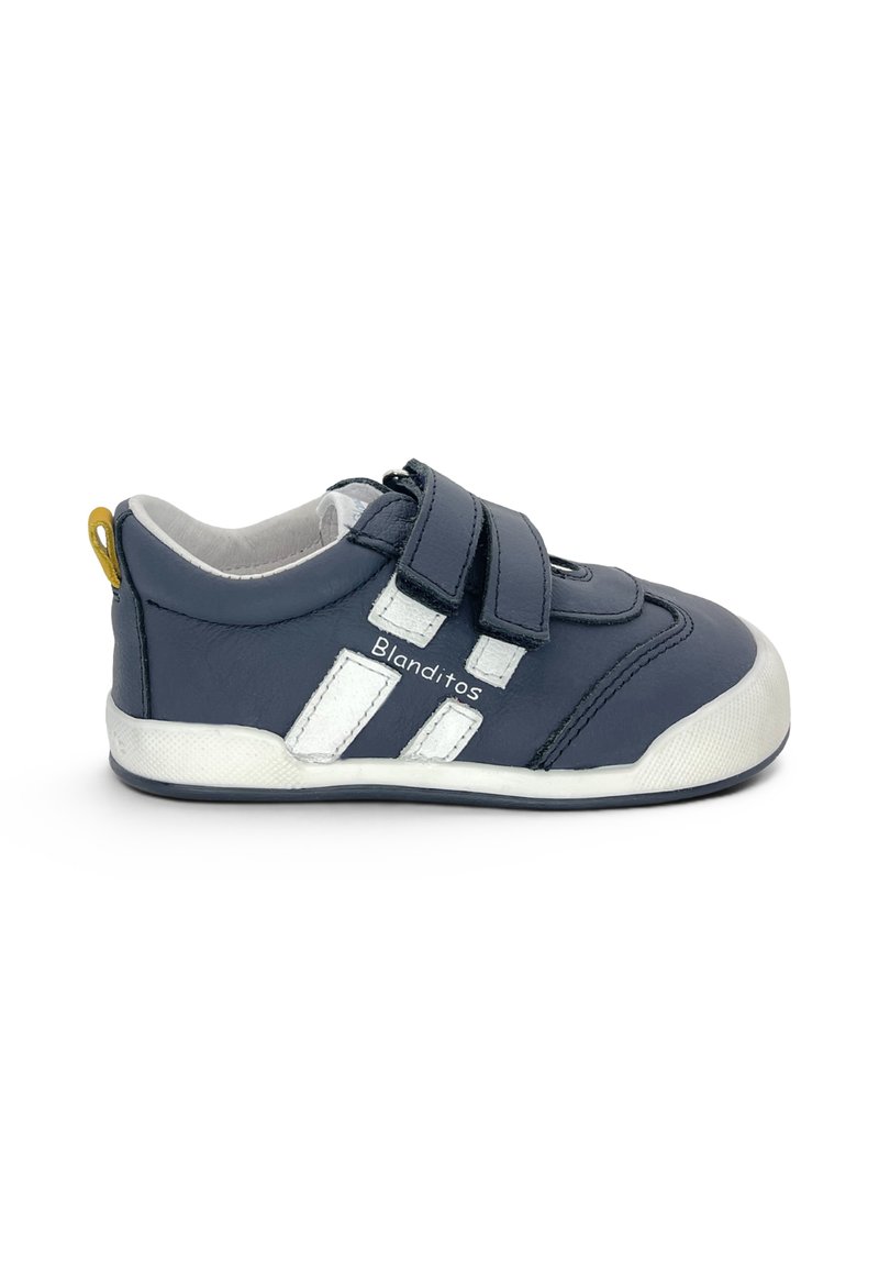 Baskets enfant bleu marine avec bandes blanches, deux scratchs, boucle jaune au talon et texte « Blanditos » sur le côté.
