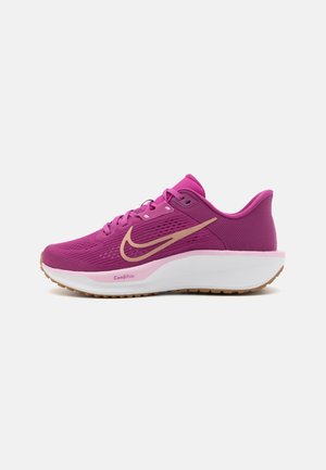 Zapatilla de running de Nike en rosa brillante, con una parte superior texturada, logo de swoosh dorado, mediasuela blanca acolchada y suela de goma marrón.
