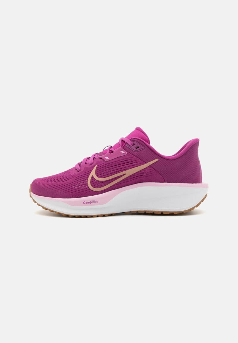 Nike running shoe in bright pink, featuring a textured upper, gold swoosh logo, cushioned white midsole, and a gum rubber outsole.