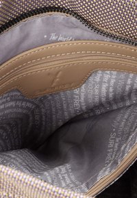 Tasca interna in pelle tan con chiusura a zip, foderata in grigio con design di testo ripetuto; materiale esterno con motivo intrecciato viola e beige.