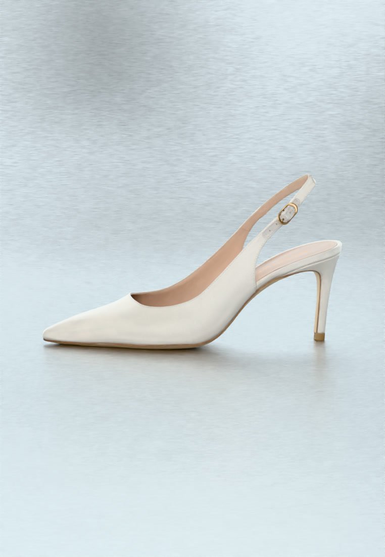 Chaussure à talon haut blanche à bout pointu avec un talon fin et une petite boucle dorée sur la bride.